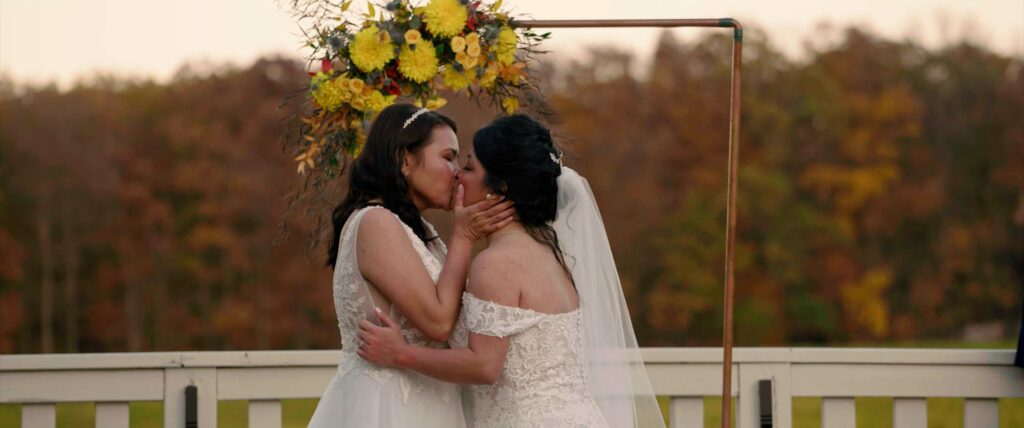 two brides first kiss at wedding ceremony